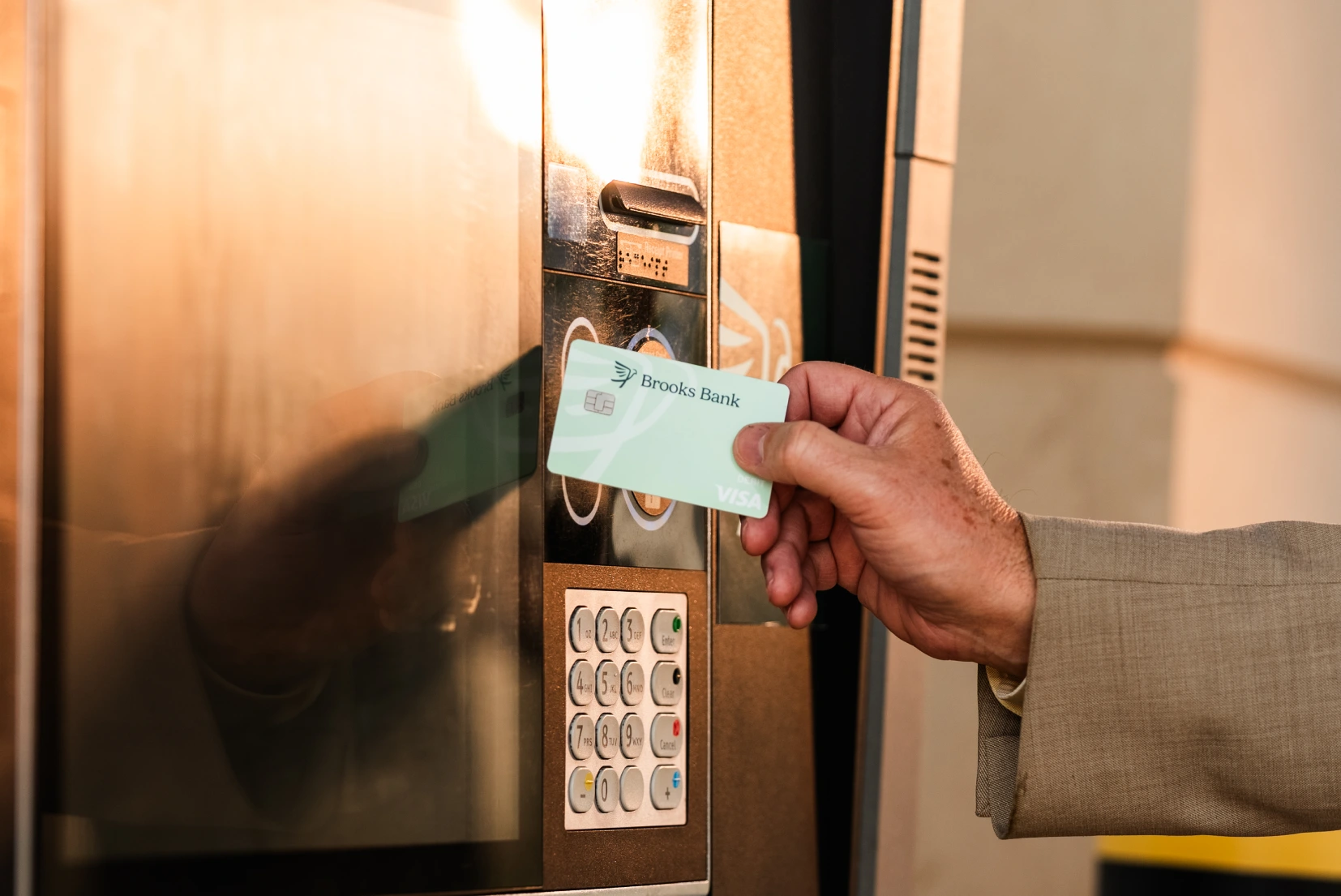 Customer tapping a Brooks Bank debit card at a drive-up ATM