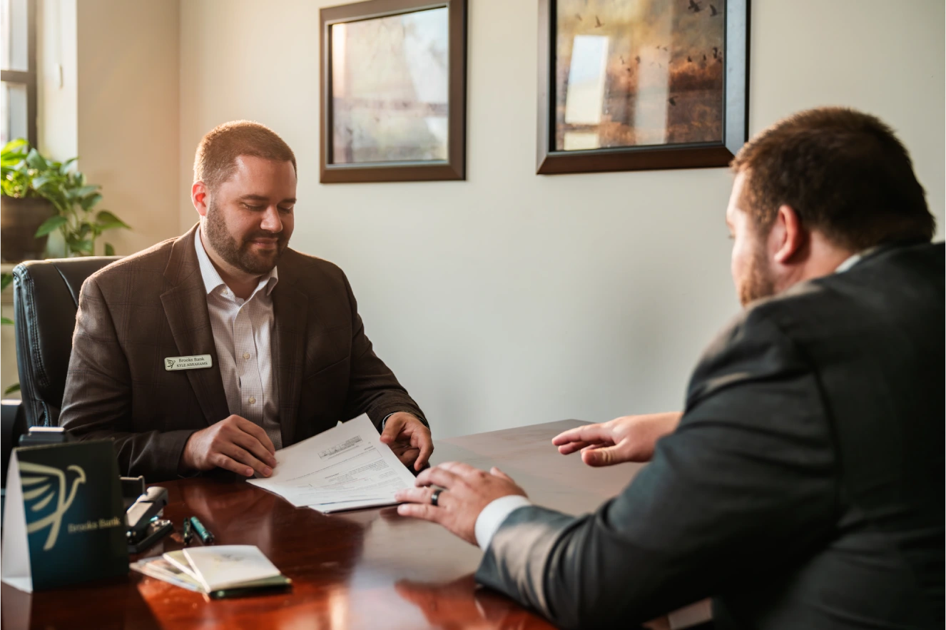 Brooks Bank loan officer reviewing paperwork with a customer