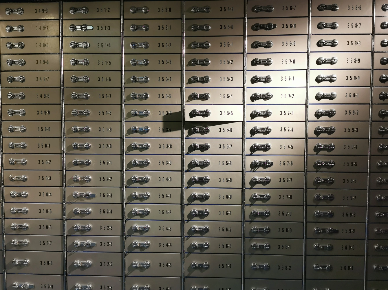 Wall of numbered safe deposit boxes in the bank vault