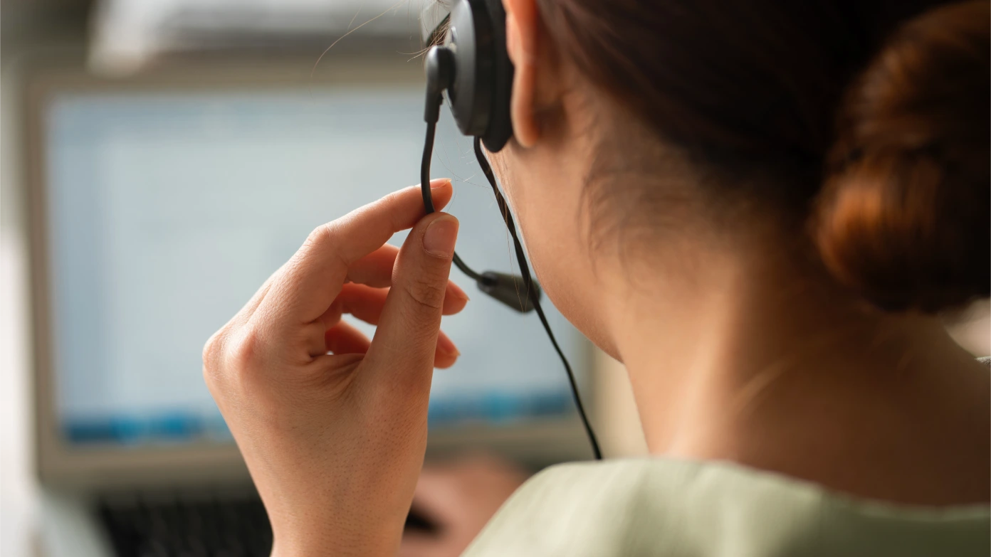 Brooks Bank representative wearing a headset at her computer
