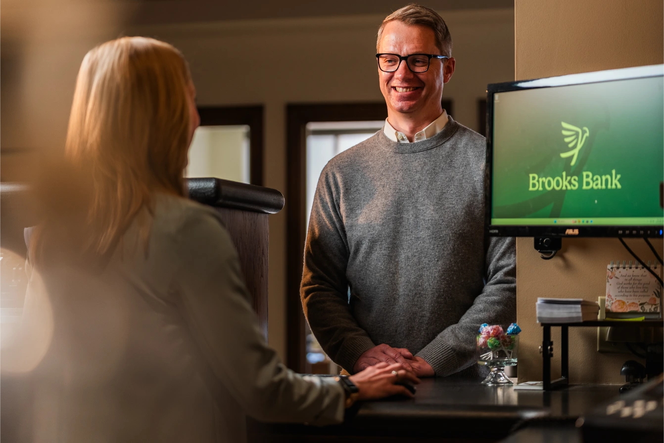 Brooks Bank banker helping a customer at a branch workstation