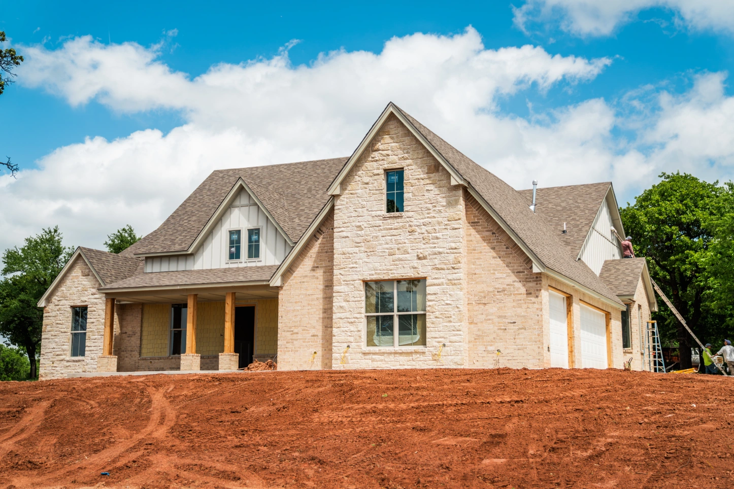 Newly built stone-and-siding home under construction on an Oklahoma lot