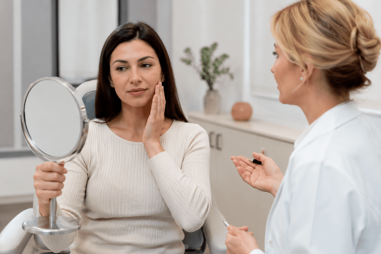 Patient learning about pillow face correction and natural facial rejuvenation at an aesthetic clinic in Greenwood, Colorado using personalized filler and collagen-stimulating treatments.