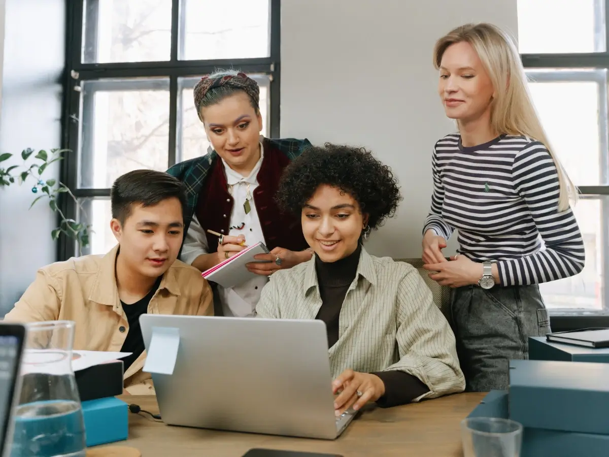 Photo of team members happily looking at their website on a laptop