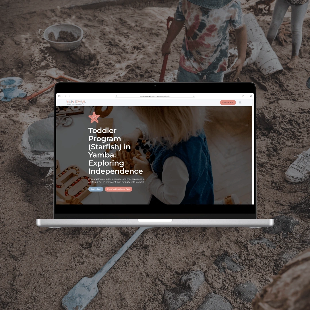 Laptop mockup set against children playing in mud, displaying the "Toddler Program (Starfish) in Yamba: Exploring Independence" page on the Seaside Explorers website