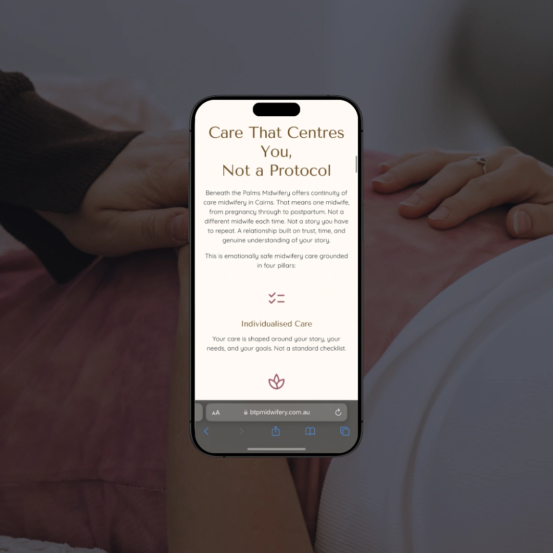 Smartphone mockup held against a pregnant belly background, displaying the "Care That Centres You, Not a Protocol" page on the Beneath the Palms Midwifery website