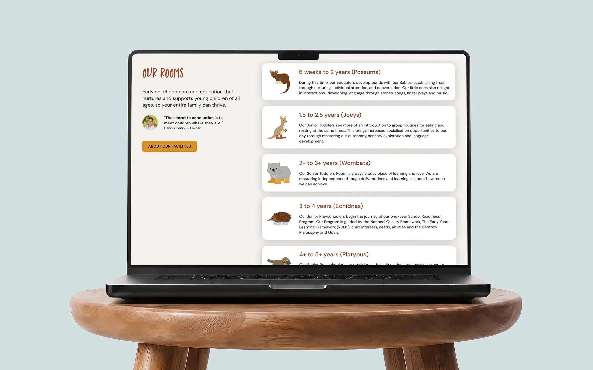 Laptop on a wooden stool showing the Bossy Boots Kingscliff 'Our Rooms' page, with age groups from Possums to Platypus