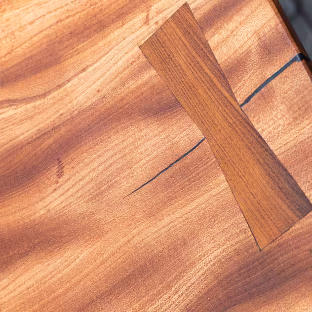 Close-up of a wooden surface with a butterfly joint fixing a crack in the wood.