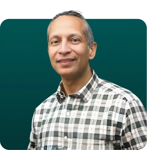 Smiling middle-aged man with short hair wearing a black and white checkered shirt against a plain dark background.