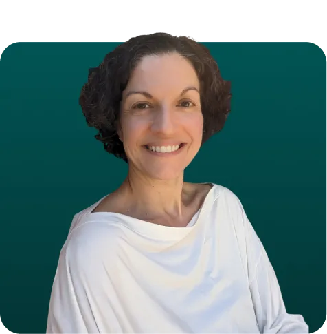 Smiling woman with short curly hair wearing a white off-shoulder top against a dark green background.