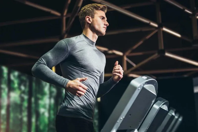 man jogging on treadmill in fitness center
