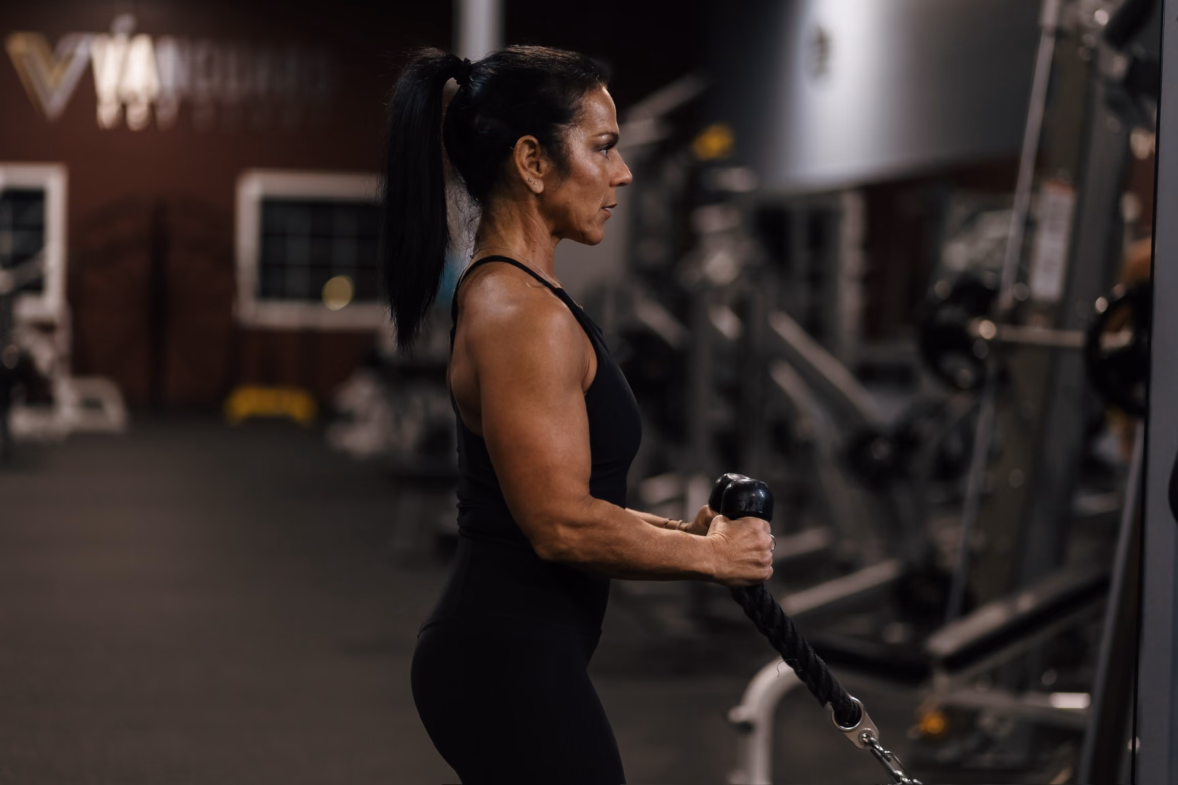 A woman working out in a Vanguard Key Clubs location doing an arm workout