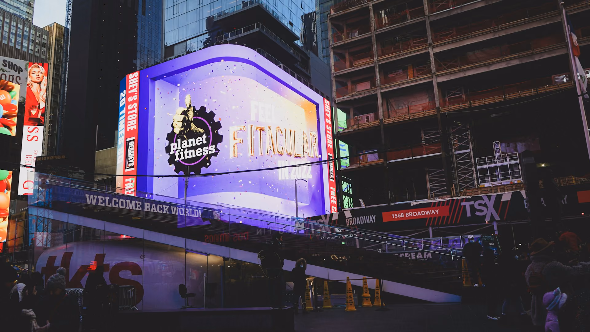 The Planet Fitness video display in Times Square, circa December 2021. Planet FItness is a massive franchise, but its overhead vastly exceeds a semi-absentee model like Vanguard Key Clubs because each location requires substantial staffing
