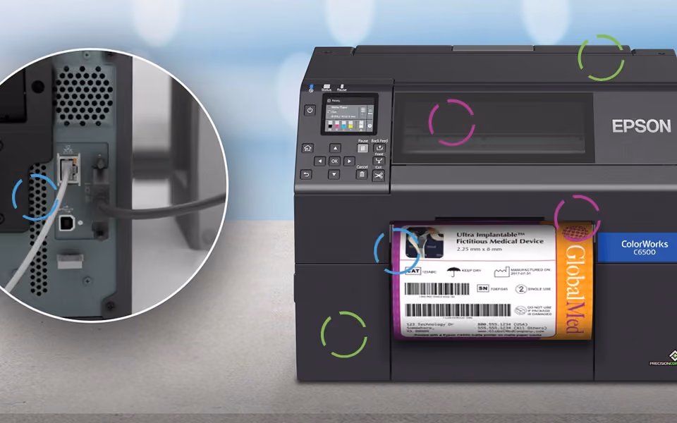 A ColorWorks printer producing a medical device label beside a lab workstation