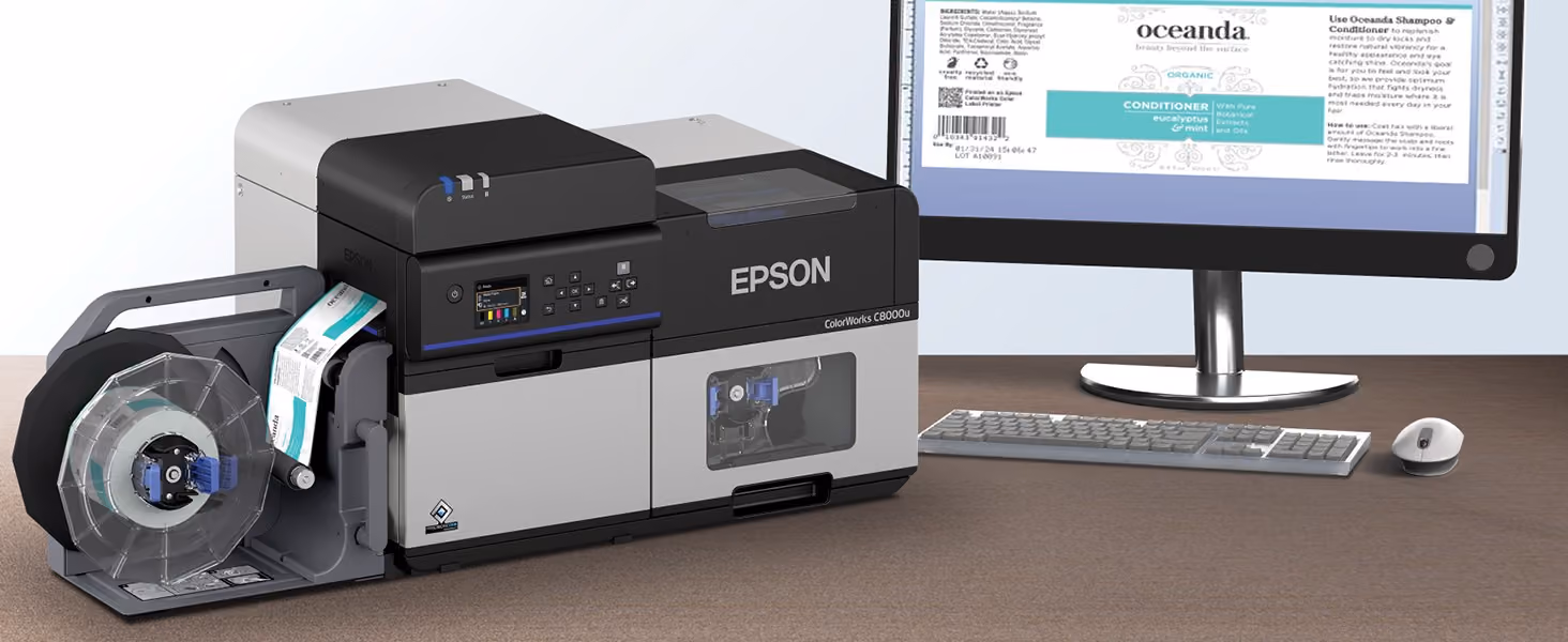 Label artwork on a monitor next to a ColorWorks CW-C8000 printing the same design