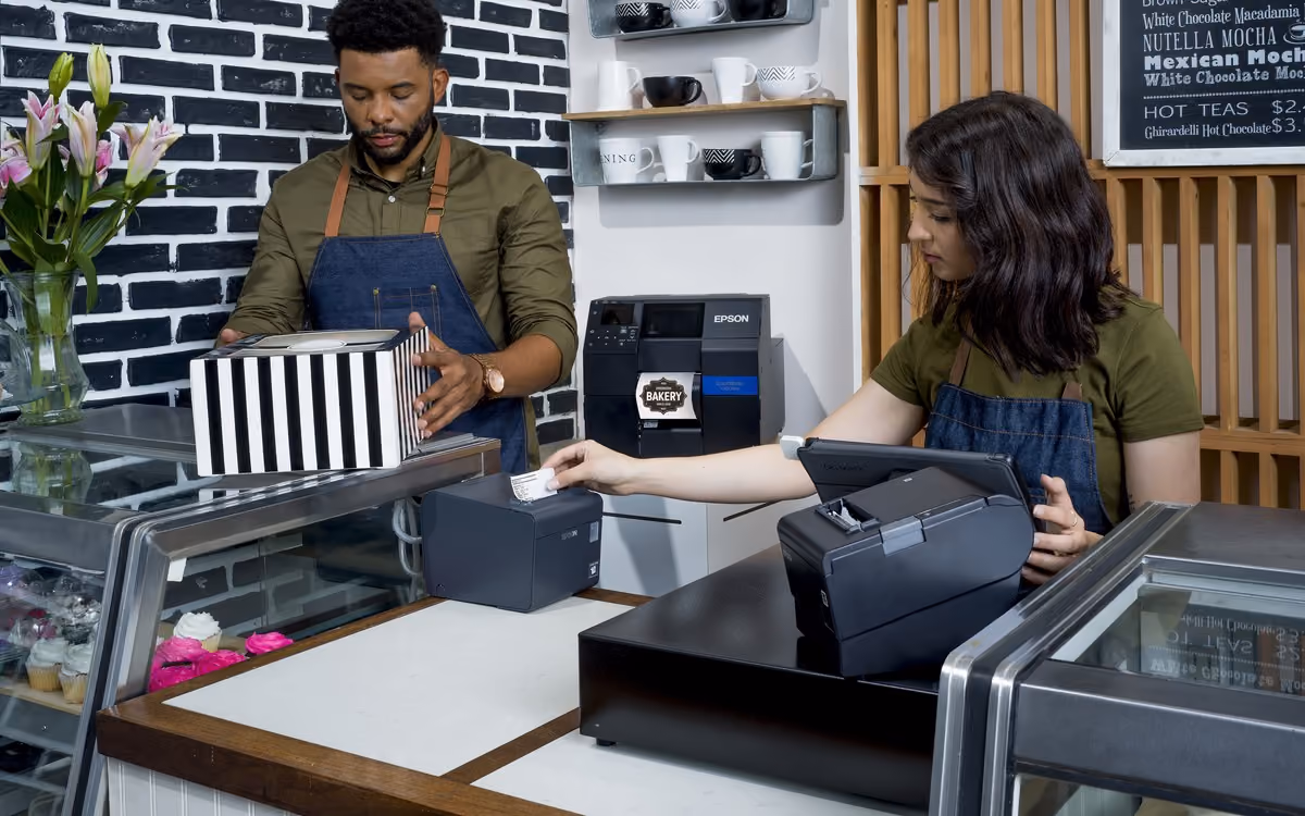 Bakery staff handing over a labelled box beside a ColorWorks printer