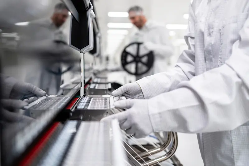 Hands connecting wires on an automotive assembly line
