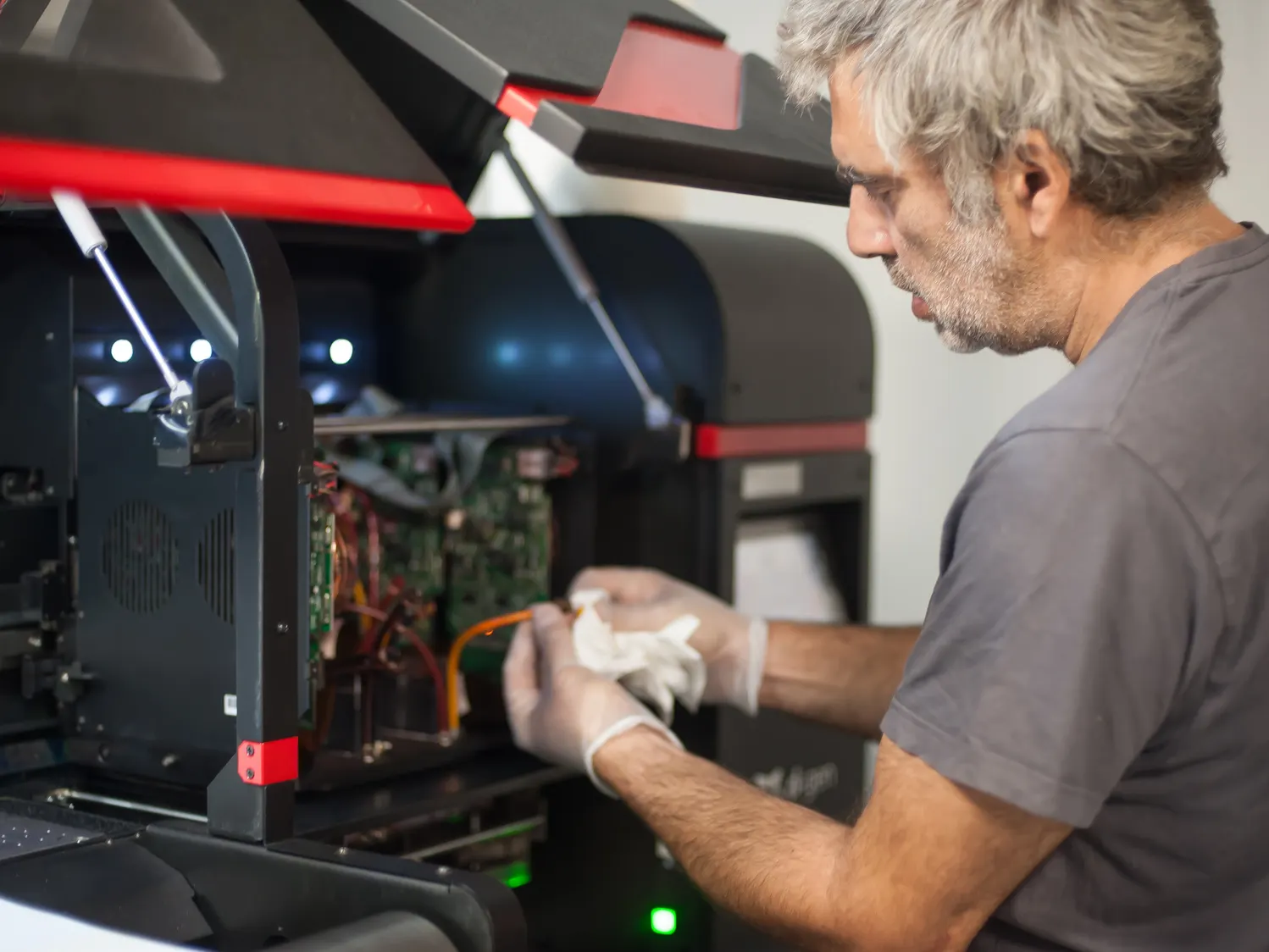 A technician working inside an open industrial printer