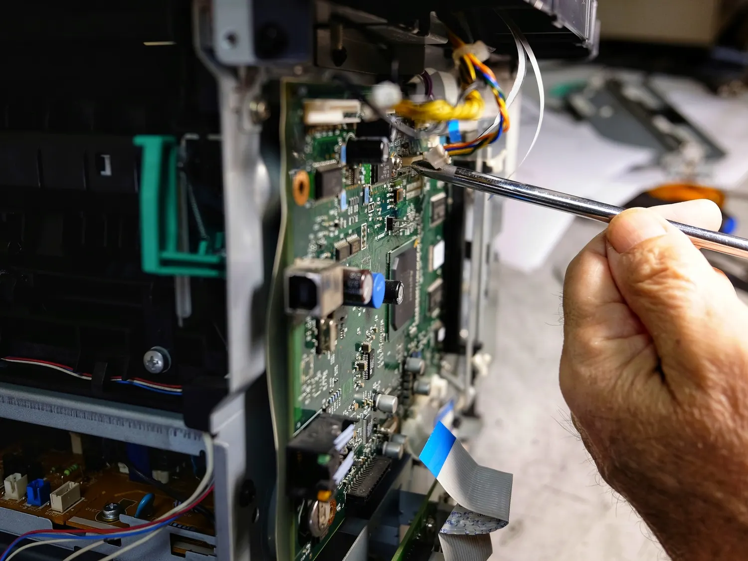 Close up of a technician repairing a printer circuit board