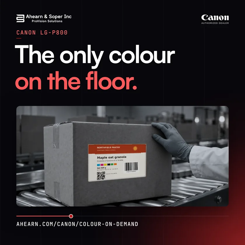 A gloved hand presses a full colour Northfield Pantry label onto a grey shipping box on a conveyor. Text: The only colour on the floor.