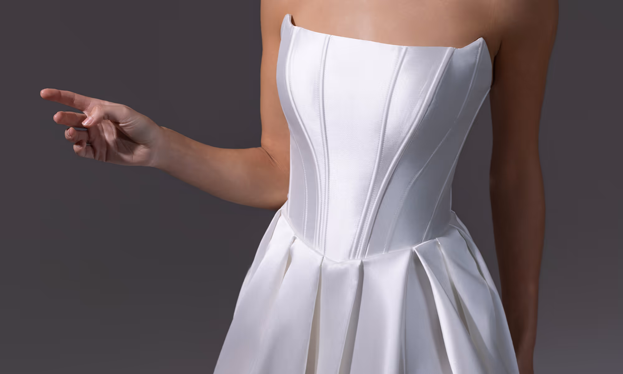 Close-up van een model dat een strapless witte satijnen jurk draagt met geplooide rok.