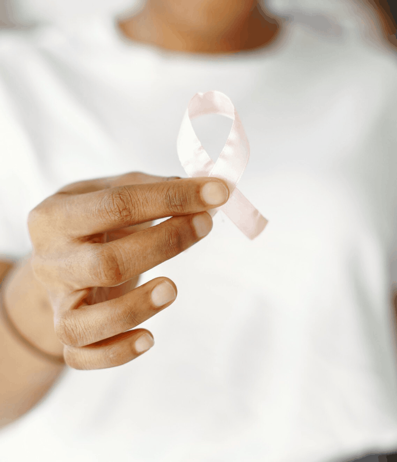 Une main tenant un ruban rose symbolisant la sensibilisation au cancer du sein.