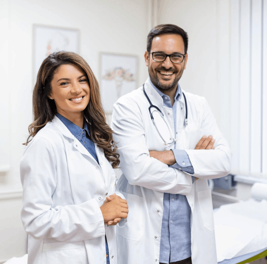 Deux médecins souriants en blouses blanches dans un cabinet médical.