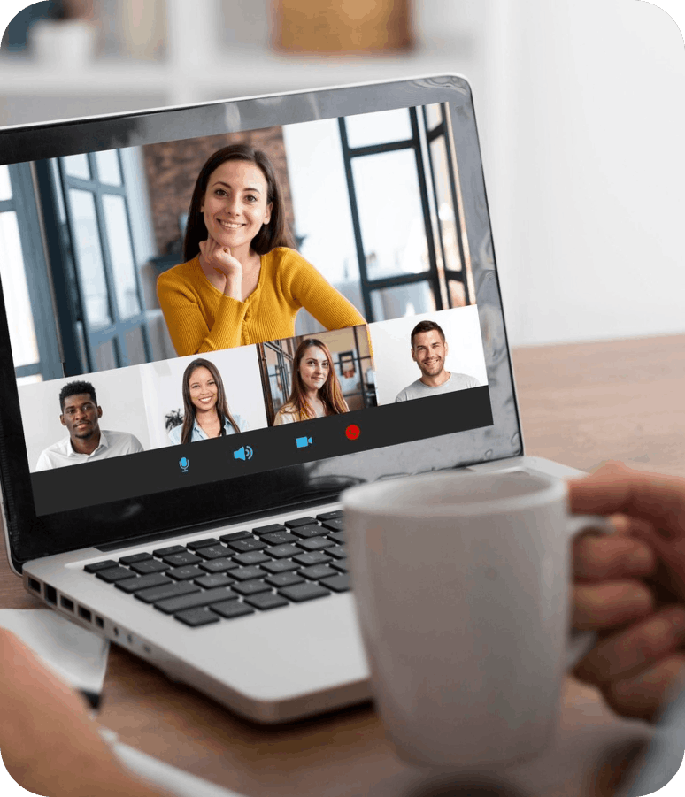 Personne participant à une visioconférence sur un ordinateur portable avec cinq autres participants visibles à l'écran.