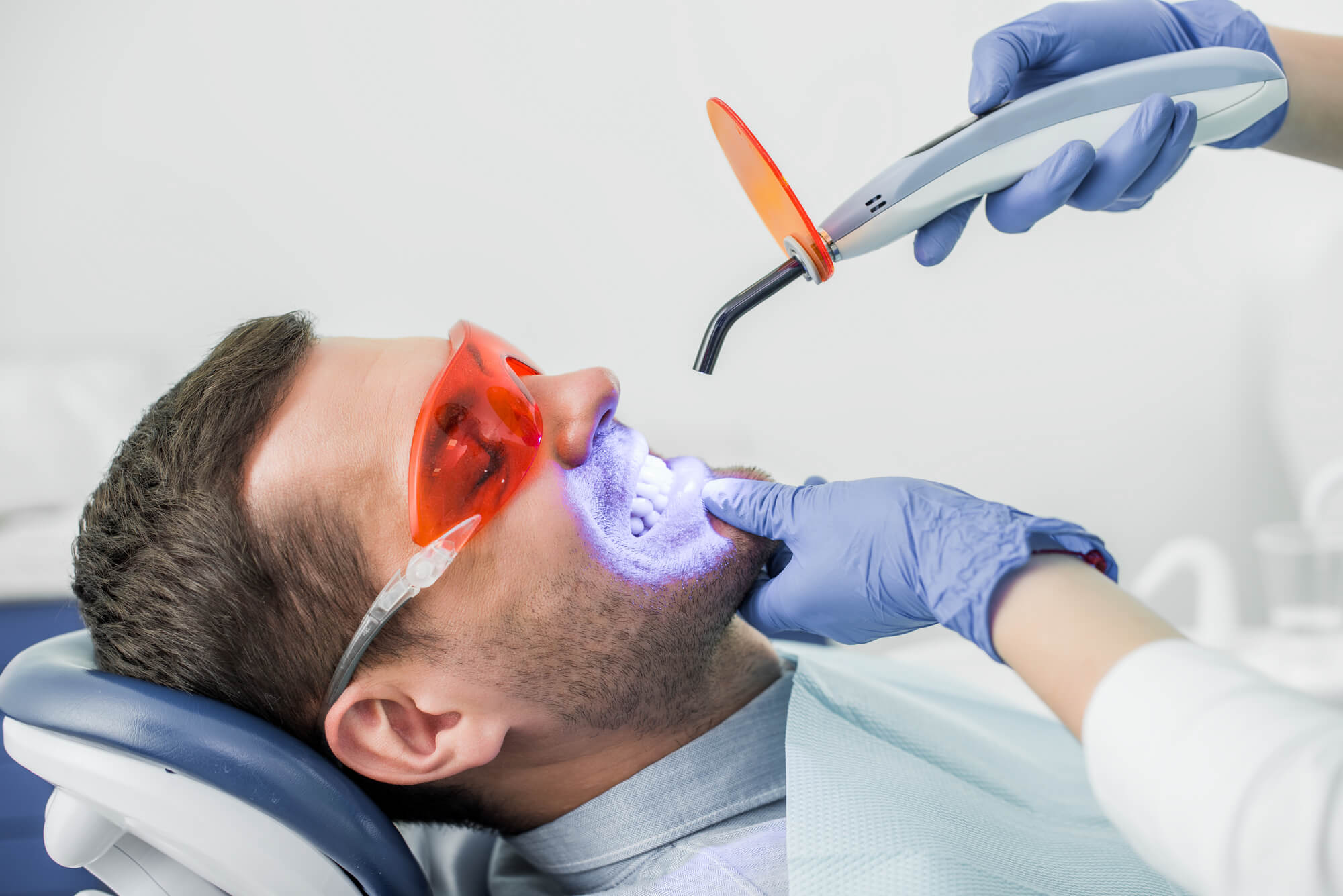 The best cosmetic dentist in orlando in the middle of a teeth whitening procedure with UV light 