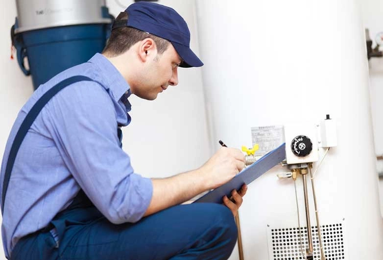 Man writing on clipboard near boiler.