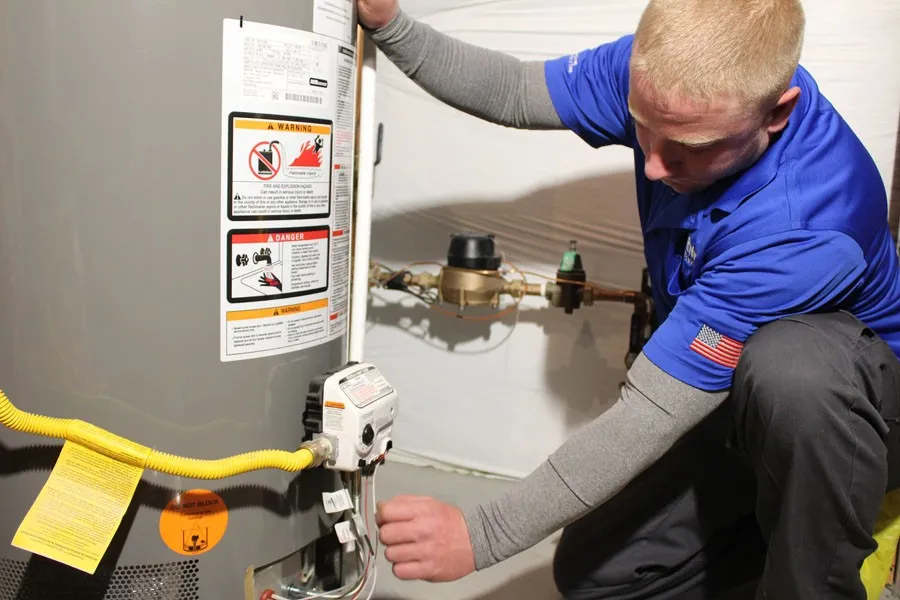 Technician connecting wires to water heater control.