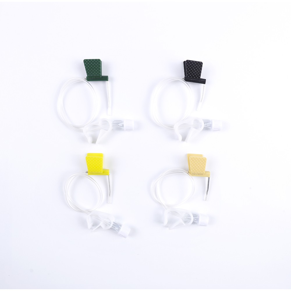 Close-up view of four IV catheters with different colored stoppers: green, black, yellow, and beige