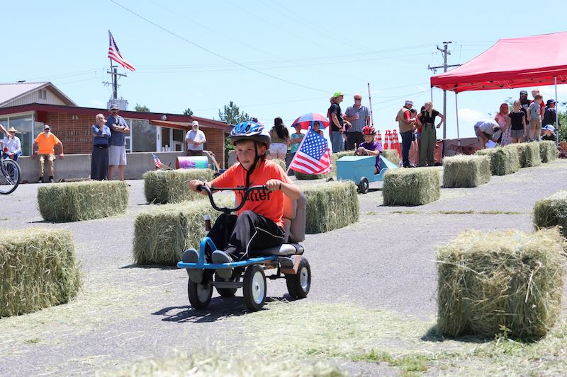 A child races their soap box car.