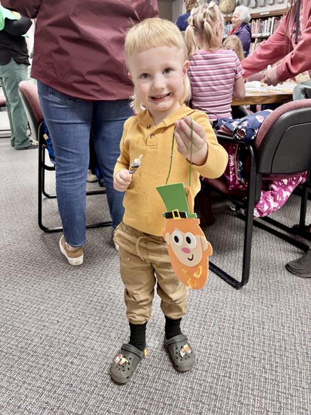 A child presents a craft for the camera after Leprechaun storytime at the Meadows Valley Library on March 11. Photo credit: Kayrene Brown