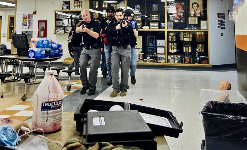 Law enforcement officers escort EMTs to triage and treat the wounded during active shooter training at Meadows Valley School. Photo credit: Rachel Reynaga.
