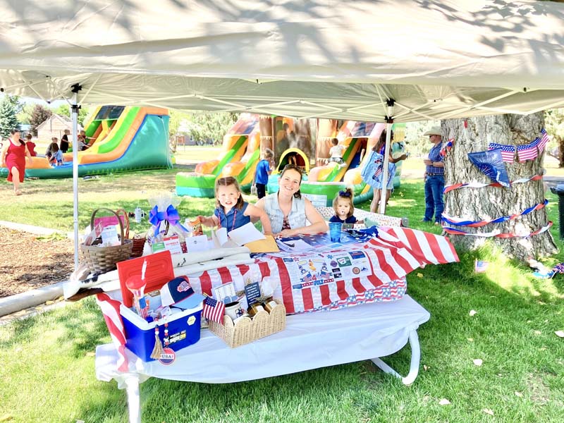 Karly Jakich and her two children sold hundreds of Duck Raffle tickets at the Midvale 4th of July celebration. Bounce houses behind her kept all the children entertained. Photo by Bonnie Evans