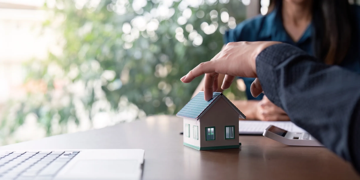 Vakuutusmyyjä ja asiakas neuvottelemassa pöydän ääressä