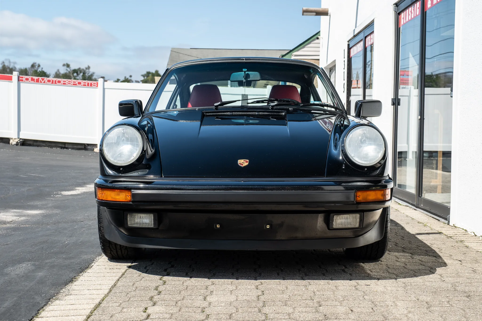 Front end shot of a Black 1988 Porsche 911 Coupe with a Red Leather interior