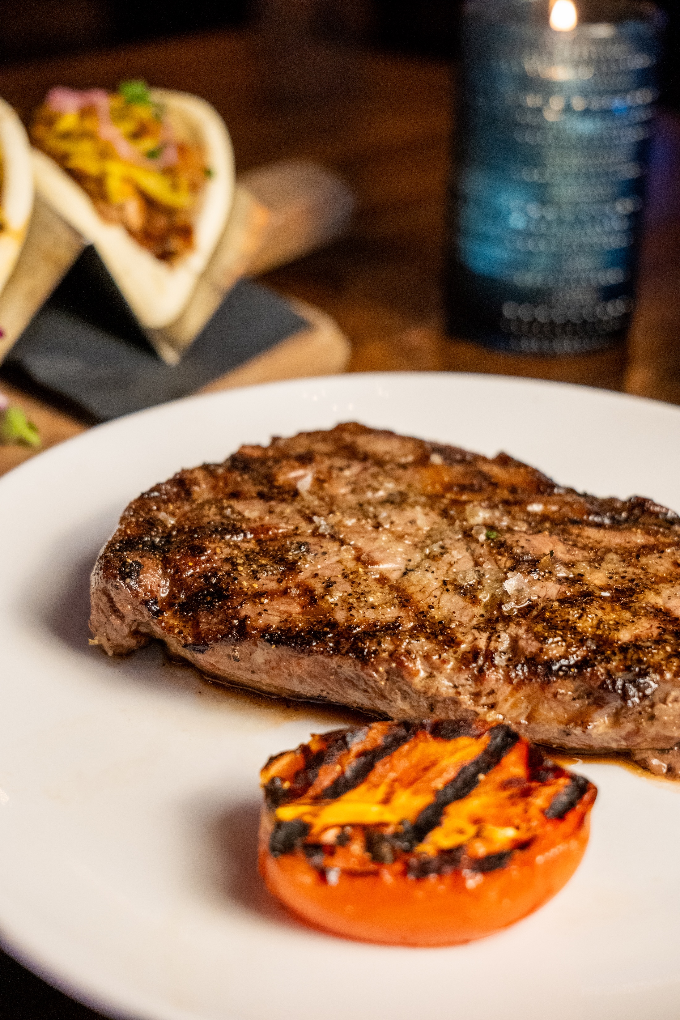 Salad with fried chicken pieces, mixed greens, cherry tomatoes, shredded cheddar cheese, pickled onions, and a side of ranch dressing.