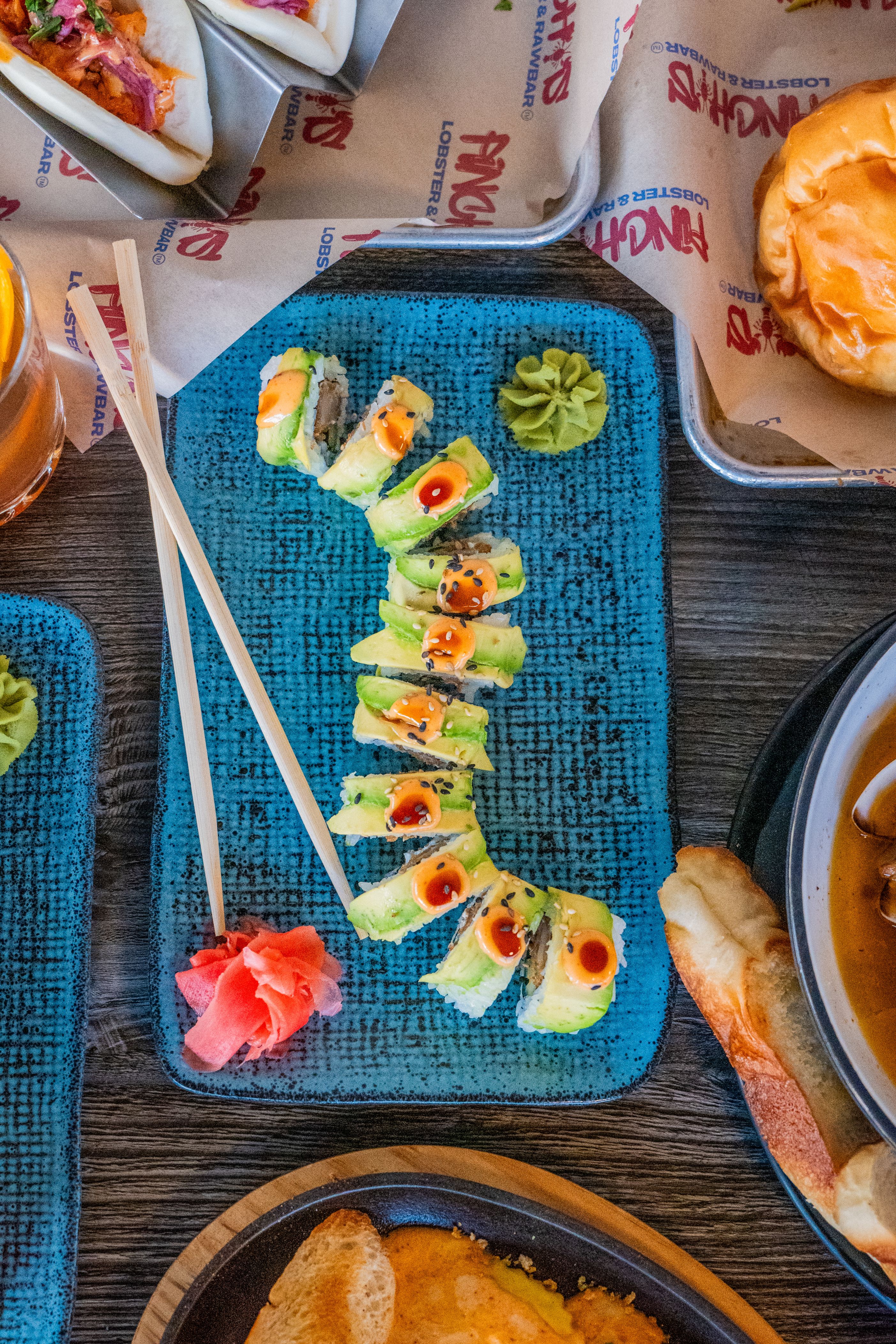 Dimly lit dining area with wooden tables and chairs, featuring a wall-mounted lantern lamp and a dark painting of a stag with antlers.