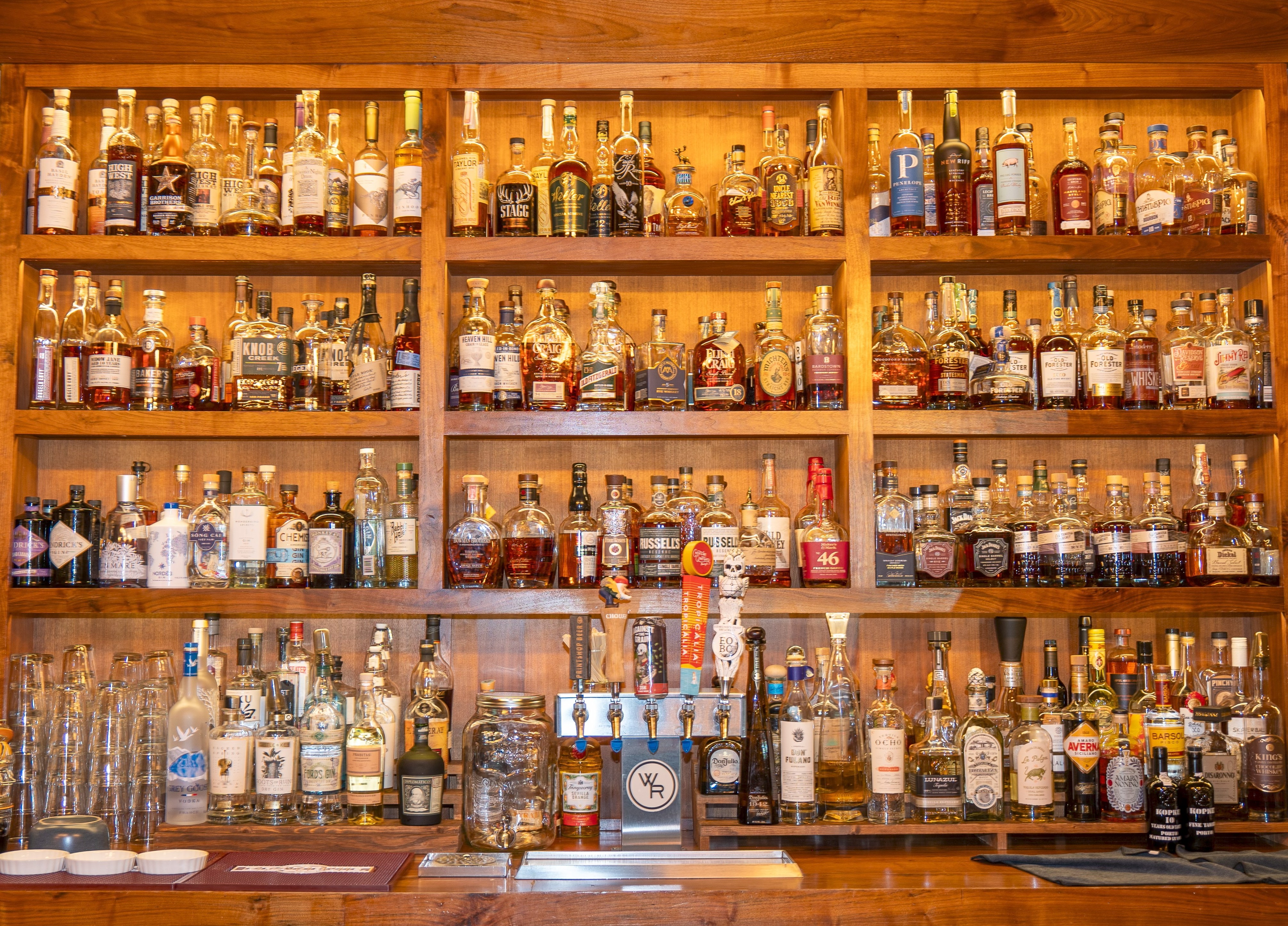 Grilled steak topped with green herb sauce and microgreens served with crispy French fries on a white plate in a restaurant setting.