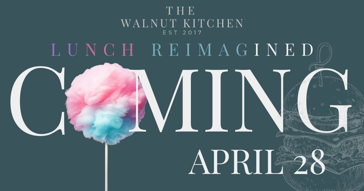 Plate with a pulled chicken sandwich on toasted bread and a side of crispy seasoned fries on a wooden table with blurred warm lights in the background.