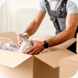 A mover packing items into a moving box