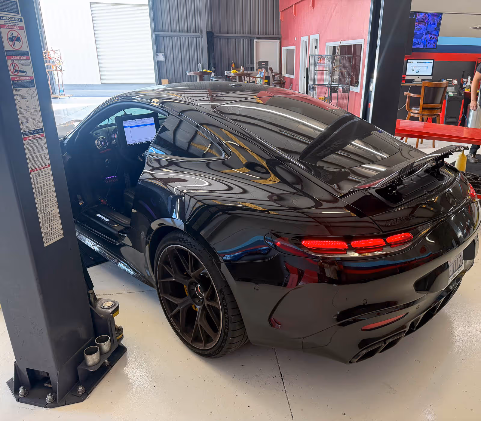 Black BMW M8 Gran Coupe on the lift at EBB in Fontana