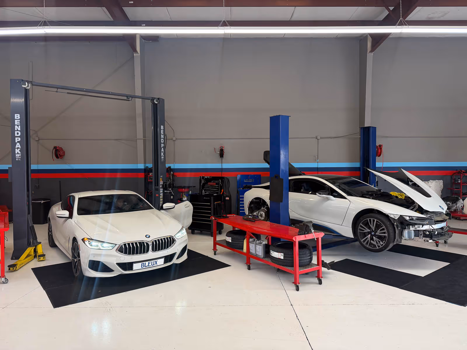 White BMW 8 Series and i8 on the lifts at EBB in Fontana