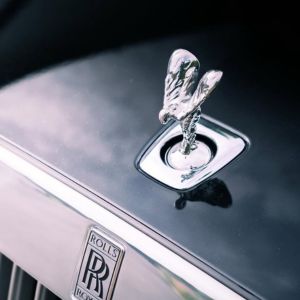 Spirit of Ecstasy hood ornament on a glossy black Rolls-Royce car hood.