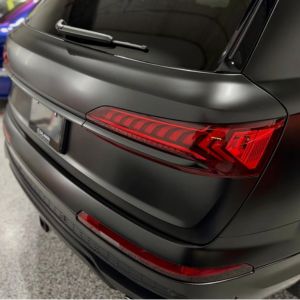 Close-up of a black SUV’s rear showing taillight, rear windshield wiper, and bumper details.