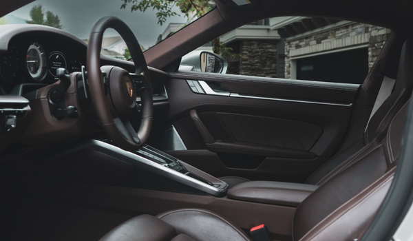 Interior of a luxury car showing brown leather seats, steering wheel, and dashboard.