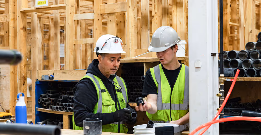 Plumbing instructor guiding an apprentice during hands-on training | Skilled Trades College