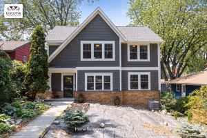 Two-story modern Craftsman-style house with dark gray horizontal siding, white trim, and a steep gabled roof by Executive Remodeling
